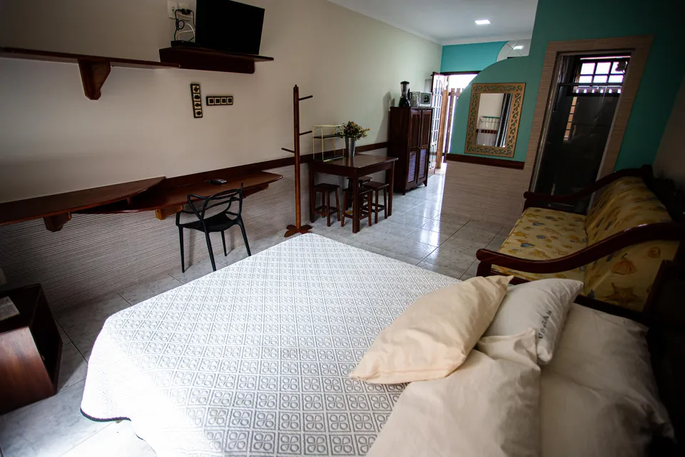 Quarto e sala integrados do loft, com cama de casal e mesa de jantar