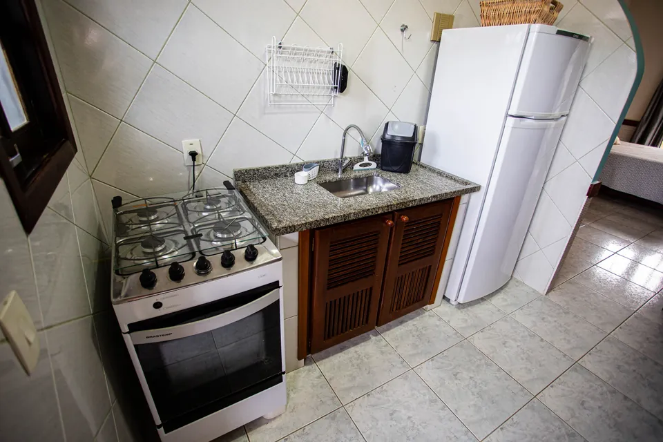 Cozinha completa do loft, com fogão, pia e geladeira