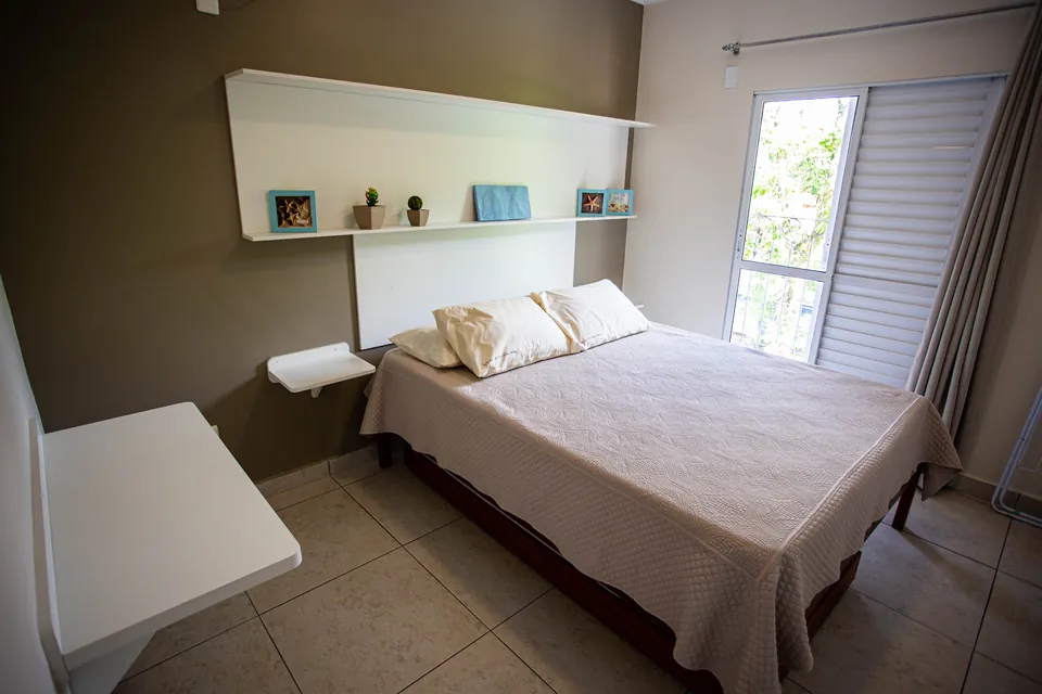 Dormitório com cama queen size do apartamento de 1 dormitório