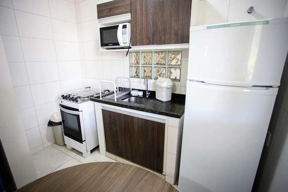 Cozinha equipada com fogão, micro-ondas e geladeira