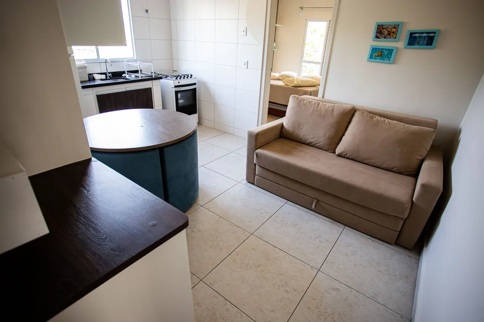Sala de estar integrada à cozinha no apartamento de 1 dormitório