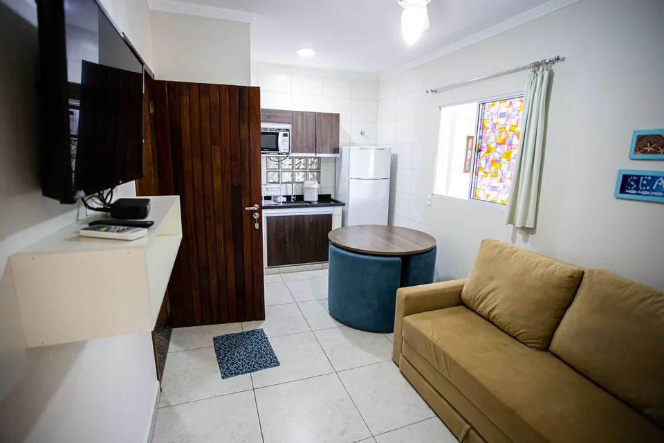 Sala com sofá e a cozinha ao fundo